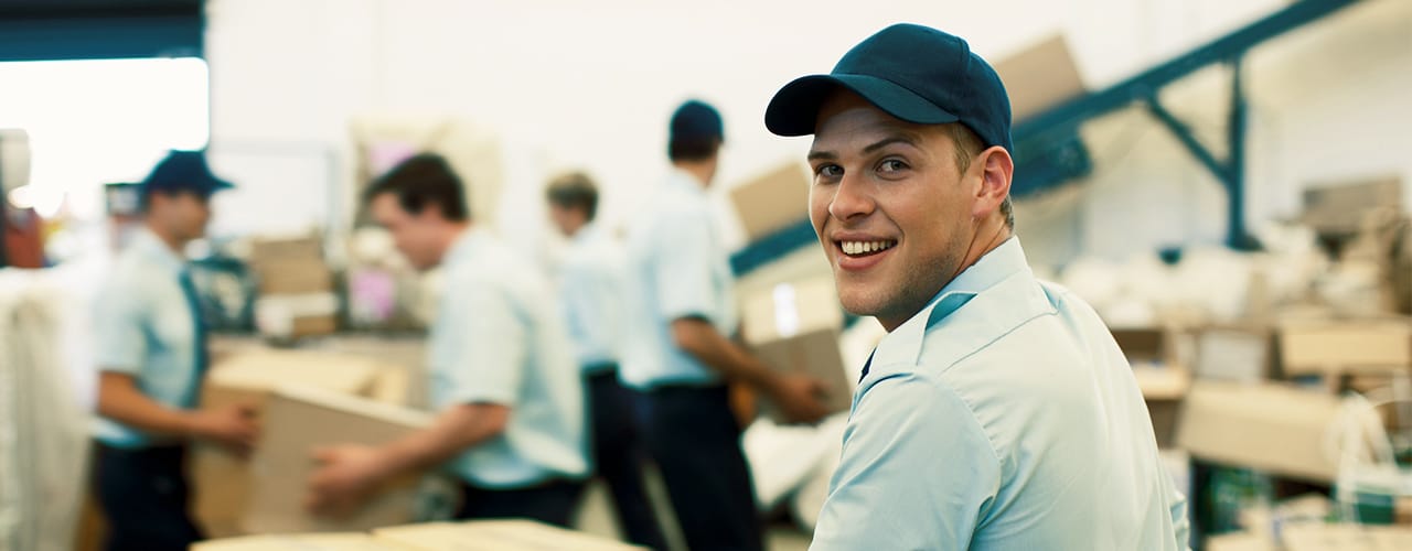Photo of a man smiling at the camera in a warehouse setting