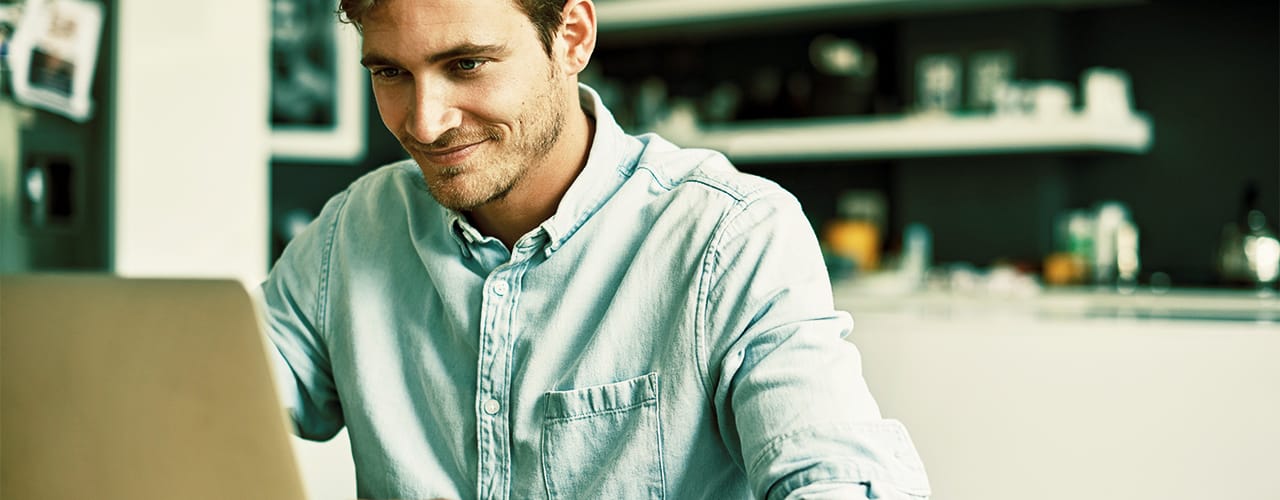 Photo of a man looking at a laptop screen